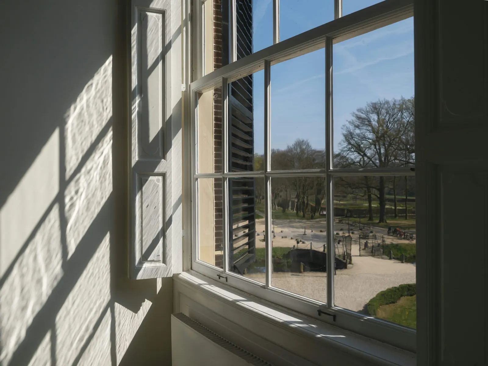 Raking daylight across a multi-pane window and its original glazing bars